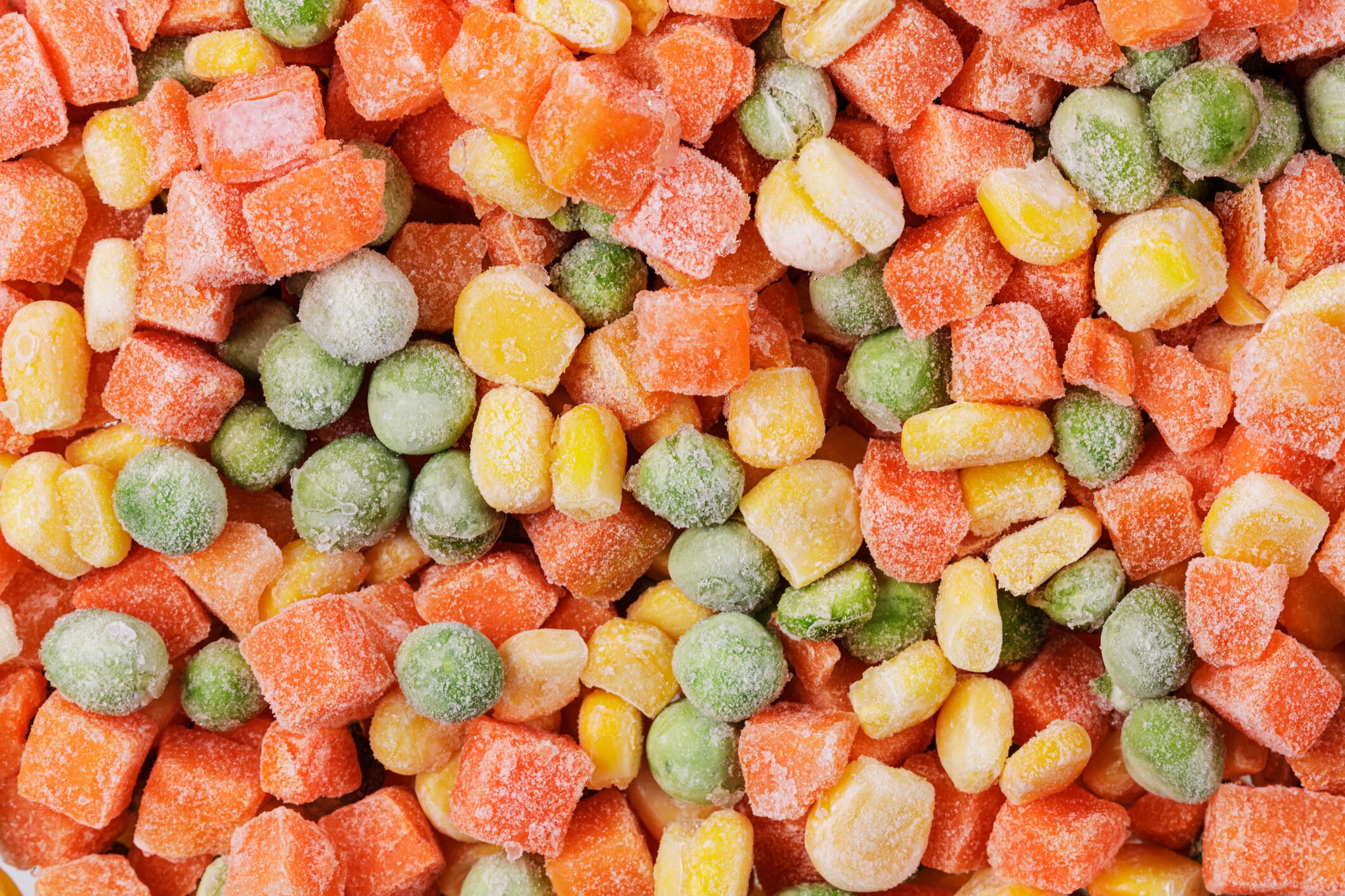 Close up of frozen mixed vegetables including Sweet Corn, Green Peas, and Carrots isolated with copy space